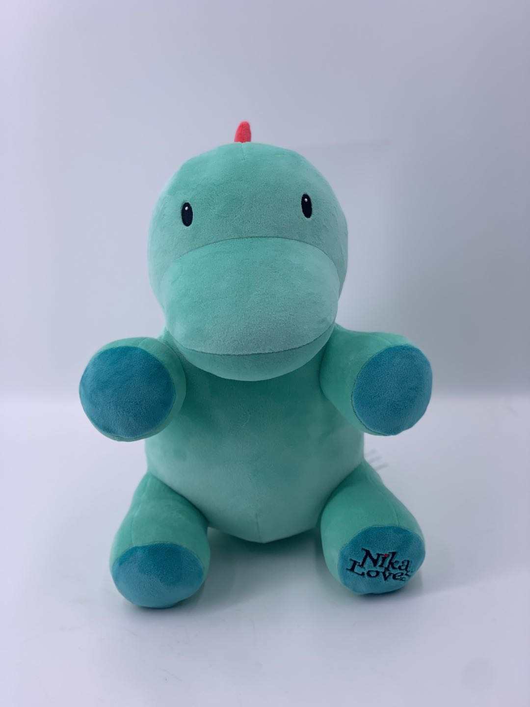 10" Genosaurus Dinosaur Plush, soft green stuffed animal with blue paws, from the Jurassic era, resembling an Ornithischian dinosaur.