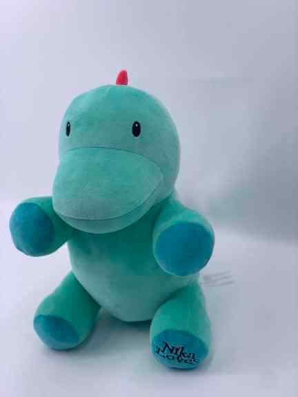 10" Genosaurus plush stuffed animal with a friendly smile and green soft fur, resembling a cute Ornithischian dinosaur.