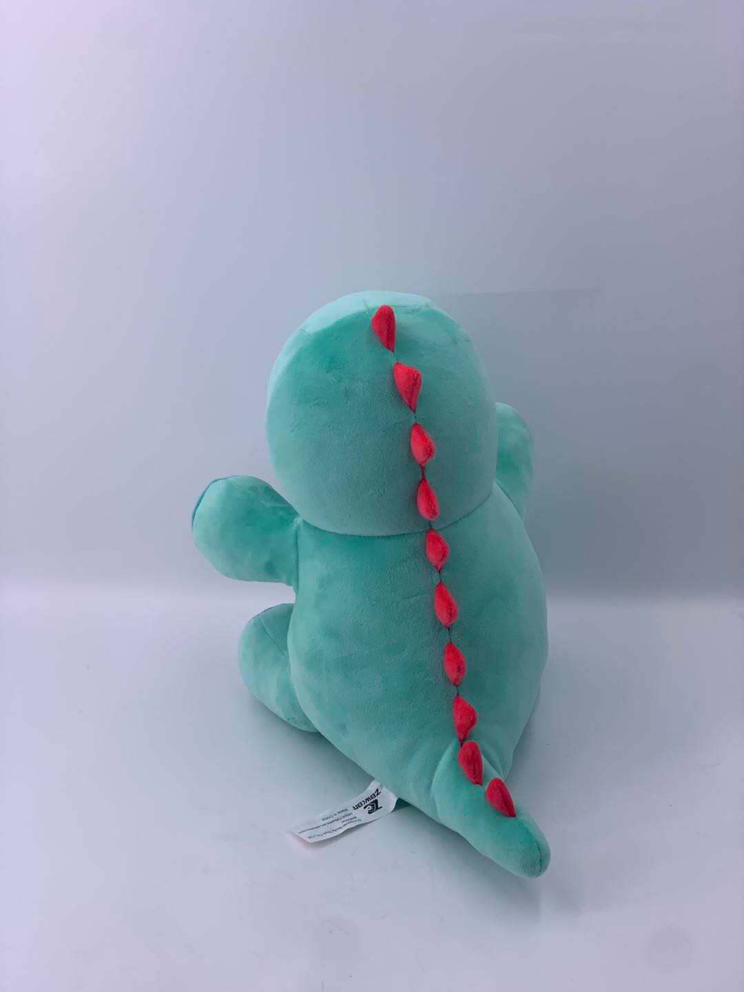 10-inch Genosaurus plush stuffed animal, soft green dinosaur toy with red spines, back view.