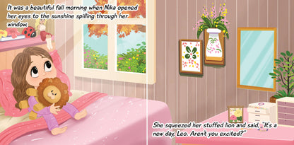 Nika waking up in bed hugging stuffed lion with sunshine spilling through window on a beautiful fall morning from children's book "Nika Loves Playing Outside."